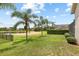 Expansive backyard featuring lush green grass, mature palm trees, and serene lake views, enhancing outdoor living at 16104 Bridgedale Dr, Lithia, FL 33547