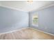 Minimalist bedroom with light blue walls, wood-look flooring, and a large window at 16104 Bridgedale Dr, Lithia, FL 33547