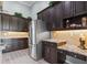 Spacious kitchen featuring granite countertops, stainless steel appliances, and dark wood cabinetry at 16104 Bridgedale Dr, Lithia, FL 33547