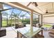 A beautiful screened patio with an outdoor dining set and comfortable seating overlooking a pond at 16104 Bridgedale Dr, Lithia, FL 33547