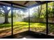 View of the backyard from screened in porch with mature trees and lawn at 1841 Georgia Ave, Palm Harbor, FL 34683