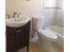 Cozy bathroom featuring a vanity with dark wood cabinetry and a toilet adjacent to a bathtub at 1841 Georgia Ave, Palm Harbor, FL 34683