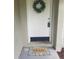 Inviting front door features a decorative wreath and a 'Home' welcome mat, adding a warm touch at 1841 Georgia Ave, Palm Harbor, FL 34683