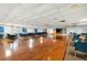 A large meeting room with a hardwood floor, tables and chairs, and a small stage at 19029 Us Highway 19 N # 5-14, Clearwater, FL 33764