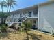 White condo building with blue accents, staircase, and tropical landscaping at 1921 58Th N Ave # 11, St Petersburg, FL 33714