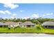 Aerial rear view of property featuring black fence, green grass, trees, and nearby pond at 19819 Tattnall Way, Brooksville, FL 34601