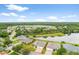 Beautiful aerial view of home near a pond and trees, in a quiet neighborhood with a blue sky with light clouds at 19819 Tattnall Way, Brooksville, FL 34601