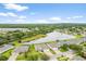 An aerial view of the home from above, showcasing its neighborhood and proximity to a pond at 19819 Tattnall Way, Brooksville, FL 34601