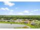 Back aerial view of house featuring a lake, green grass, and blue sky with white clouds at 19819 Tattnall Way, Brooksville, FL 34601