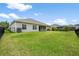 Fenced backyard with green grass and view of the home's exterior at 19819 Tattnall Way, Brooksville, FL 34601