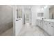 Bright bathroom showcases a marble tiled floor, glass shower, and double sink vanity at 19819 Tattnall Way, Brooksville, FL 34601