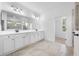 Modern bathroom showcasing marble floors, double sink vanity, and a glass enclosed shower at 19819 Tattnall Way, Brooksville, FL 34601