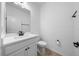 This bathroom features a toilet, sink, mirror, and stylish hardware at 19819 Tattnall Way, Brooksville, FL 34601