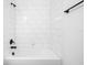 Modern bathroom features a clean white tub and shower with matte black fixtures at 19819 Tattnall Way, Brooksville, FL 34601