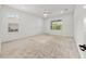 A spacious bedroom with plenty of natural light flooding in through two windows and carpet flooring at 19819 Tattnall Way, Brooksville, FL 34601