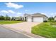 The house featuring a three car garage and paved drive at 19819 Tattnall Way, Brooksville, FL 34601