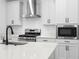 Modern kitchen featuring a stainless steel range hood and appliances, complete with stylish cabinetry and fixtures at 19819 Tattnall Way, Brooksville, FL 34601
