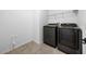 Well-lit laundry room with modern washer and dryer units, plus tile flooring at 19819 Tattnall Way, Brooksville, FL 34601