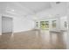 Bright living room featuring tray ceiling, fan, and sliding glass doors leading to the backyard at 19819 Tattnall Way, Brooksville, FL 34601