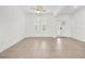 Bright living room with tile flooring, white walls, and natural light from windows next to a door at 19819 Tattnall Way, Brooksville, FL 34601