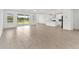 Open living room with tiled floor, large windows and doors, connects to the kitchen at 19819 Tattnall Way, Brooksville, FL 34601