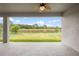 Covered patio overlooking well maintained backyard with mature trees and pond at 19819 Tattnall Way, Brooksville, FL 34601