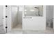 Bathroom featuring a spacious shower with white marble tiling and a glass partition at 19819 Tattnall Way, Brooksville, FL 34601