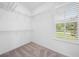 Walk-in closet featuring wire shelving, carpet flooring, and a window with plantation shutters at 19819 Tattnall Way, Brooksville, FL 34601