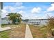 Waterfront backyard featuring lush palm trees, boat dock, patio dining and picturesque views at 2010 20Th Avenue Pkwy, Indian Rocks Beach, FL 33785