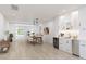 Bright dining room with modern white cabinetry, dining table, and a clear glass front door at 2010 20Th Avenue Pkwy, Indian Rocks Beach, FL 33785