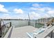 Waterfront dock with three chairs facing beautiful river views, houses, and clear skies at 2010 20Th Avenue Pkwy, Indian Rocks Beach, FL 33785