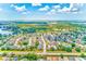 Scenic aerial view of a well-planned neighborhood with tree-lined streets, charming houses, and serene lake views in the distance at 22943 Sills Loop, Land O Lakes, FL 34639