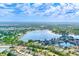 Expansive aerial view of a lakeside community featuring lush landscaping, beautiful blue skies, and shimmering lake views at 22943 Sills Loop, Land O Lakes, FL 34639