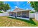 A view of the house from the fenced backyard shows the screened-in lanai at 22943 Sills Loop, Land O Lakes, FL 34639