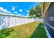 A view of the spacious backyard with lush lawn and white vinyl fencing at 22943 Sills Loop, Land O Lakes, FL 34639