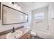 Bright bathroom features an updated vanity, faucet and large mirror, along with a tub and shower combo at 22943 Sills Loop, Land O Lakes, FL 34639