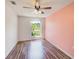 Bright bedroom features stylish ceiling fan, lovely wood-look floors, and large window with scenic views at 22943 Sills Loop, Land O Lakes, FL 34639