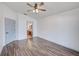 Bedroom with wood-look floors, ceiling fan, and en-suite bathroom access ensures convenience and comfort at 22943 Sills Loop, Land O Lakes, FL 34639