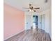 Bedroom with wood-look floors, a pink accent wall, and double closets makes for a cozy retreat at 22943 Sills Loop, Land O Lakes, FL 34639