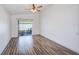 Bedroom with wood-look floors, ceiling fan, and sliding glass door to patio creates a relaxing retreat at 22943 Sills Loop, Land O Lakes, FL 34639