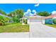 Exterior facade of home boasts an attached two-car garage and landscaped lawn at 22943 Sills Loop, Land O Lakes, FL 34639
