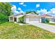 Charming single-story home featuring a well-manicured lawn and attached two-car garage at 22943 Sills Loop, Land O Lakes, FL 34639