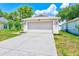 Exterior facade of home boasts an attached two-car garage and landscaped lawn at 22943 Sills Loop, Land O Lakes, FL 34639