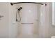 Shower featuring white tile, accessibility bar, and handheld shower head provides a clean and accessible space at 22943 Sills Loop, Land O Lakes, FL 34639