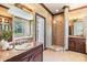Luxurious bathroom boasts granite countertops, a glass enclosed shower, and a soaking tub beneath a window at 2354 Messenger Cir, Safety Harbor, FL 34695