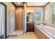 Bathroom featuring tile floors, granite countertop, soaking tub and glass shower at 2354 Messenger Cir, Safety Harbor, FL 34695