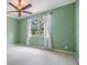 Bedroom featuring decorative green walls, ceiling fan and a bright window at 2354 Messenger Cir, Safety Harbor, FL 34695