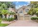 Stunning two-story home featuring a red tile roof, two-car garage, and beautiful landscaping at 2354 Messenger Cir, Safety Harbor, FL 34695