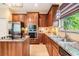 A view of the kitchen with wood cabinets, stainless appliances, and granite countertops at 2354 Messenger Cir, Safety Harbor, FL 34695