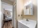 Bathroom with white vanity, mirror, and open doorway to a bedroom at 2597 Countryside Blvd # 210, Clearwater, FL 33761